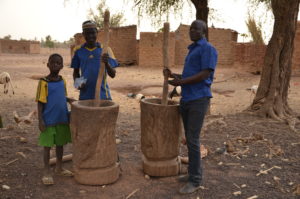Burkinabés moulant des céréales